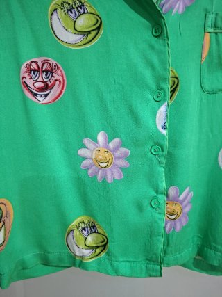 Camisa verde con estampado de caras y flores