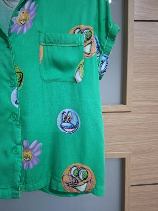 Camisa verde con estampado de caras y flores