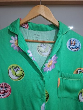 Camisa verde con estampado de caras y flores