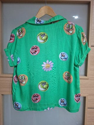Camisa verde con estampado de caras y flores