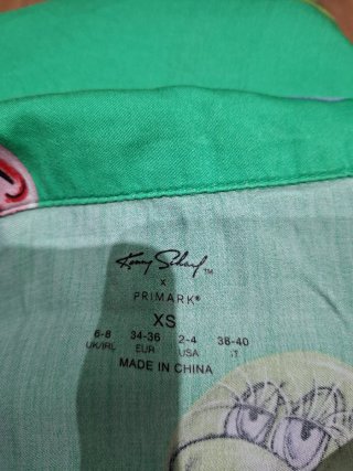 Camisa verde con estampado de caras y flores