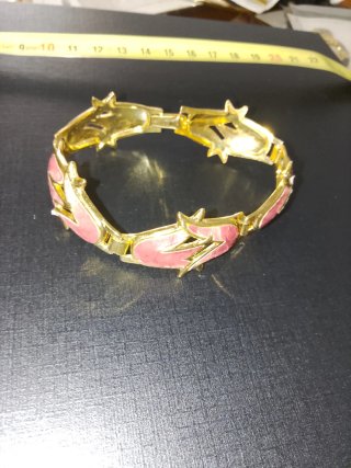 Pulsera dorada con detalles en rosa