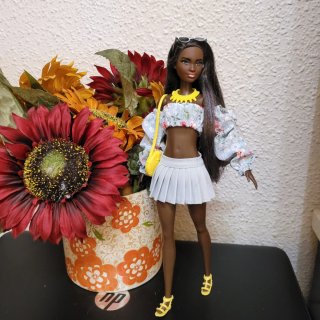Muñeca barbie con vestido floral y bolso amarillo