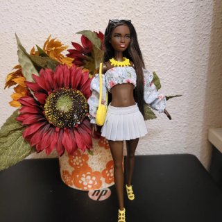 Muñeca barbie con vestido floral y bolso amarillo