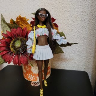 Muñeca barbie con vestido floral y bolso amarillo