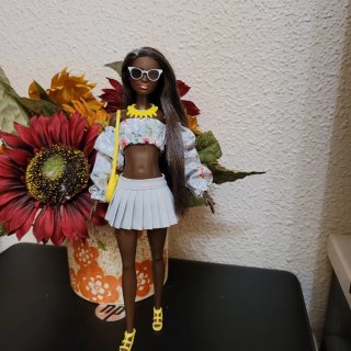 Muñeca barbie con vestido floral y bolso amarillo