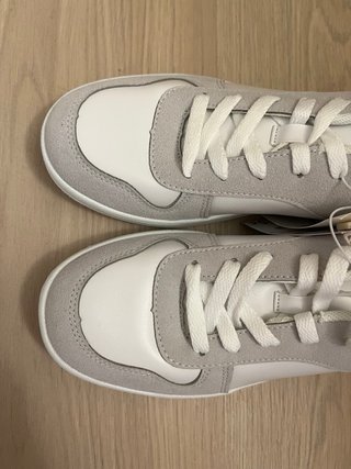 Zapatillas blancas y grises con etiqueta