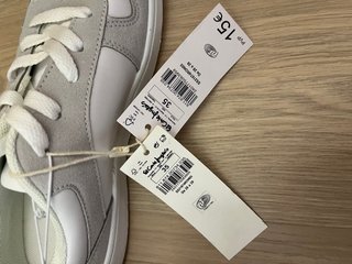 Zapatillas blancas y grises con etiqueta