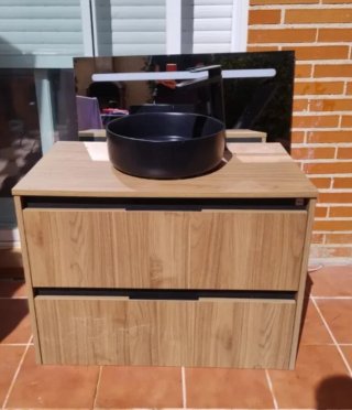 Mueble de baño con lavabo y grifo.