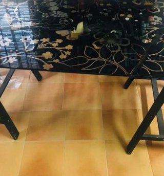 Mesa de cristal negra con diseño floral dorado