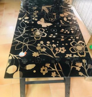 Mesa de cristal negra con diseño floral dorado