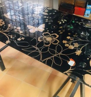 Mesa de cristal negra con diseño floral dorado