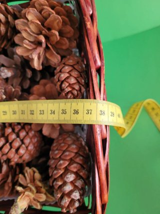 Cesto de mimbre con piñas decorativas