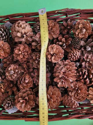 Cesto de mimbre con piñas decorativas