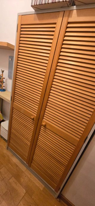 Armario de madera con puertas de lamas.
