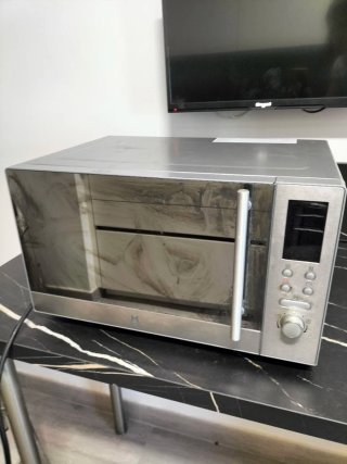 Microondas plateado con puerta de cristal