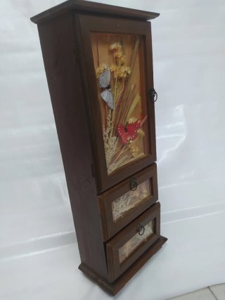 Pequeño mueble decorativo con puerta y cajones.