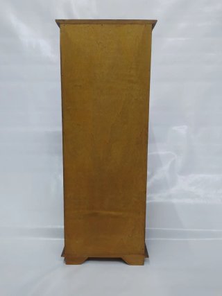 Pequeño mueble decorativo con puerta y cajones.