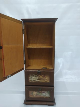 Pequeño mueble decorativo con puerta y cajones.
