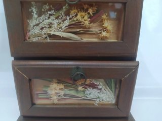 Pequeño mueble decorativo con puerta y cajones.