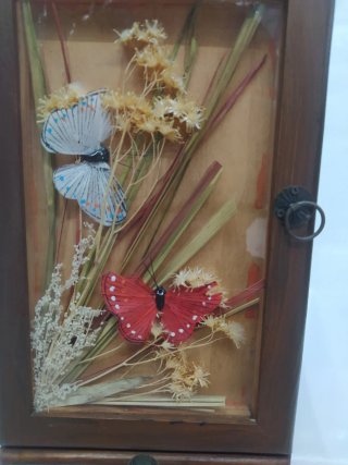 Pequeño mueble decorativo con puerta y cajones.