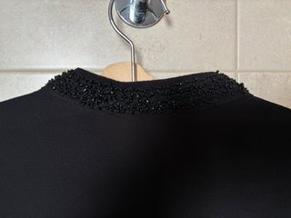 Blusa negra fluida con pedreria en cuello y mangas