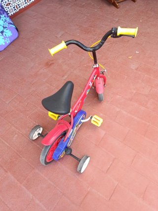 Bicicleta infantil roja con ruedas de apoyo