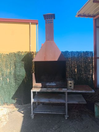 Barbacoa exterior metálica con chimenea