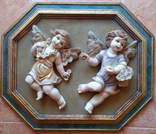 Ángeles o querubines en relieve sobre marco.