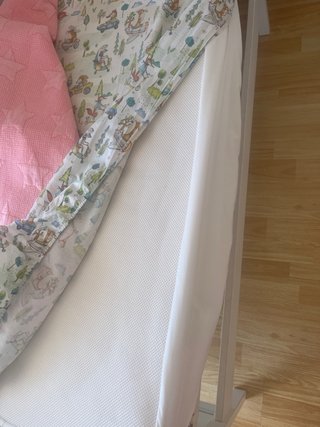 Cuna blanca con manta rosa de estrellas