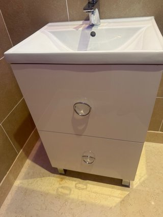 Mueble de baño con lavabo, grifo, espejo.