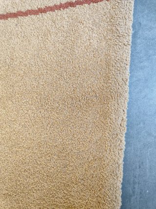 Alfombra beige con diseño de líneas curvas