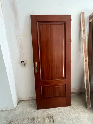 Puerta de madera marrón con manilla dorada