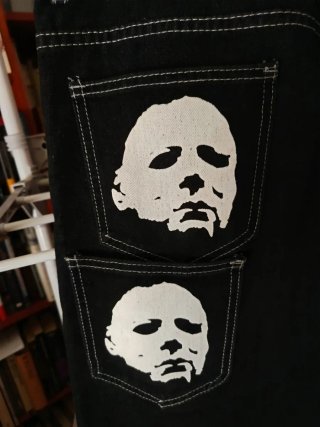 Pantalones negros con diseño de murciélago.