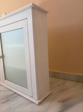 Mueble de baño blanco con puerta de cristal