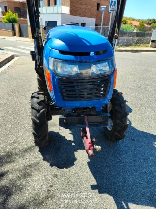 Tractor azul con pala frontal