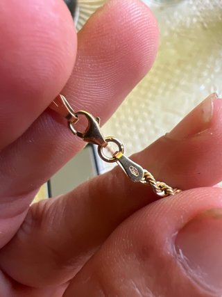 Un anillo de oro de 18k y un cordon de oro de 18k