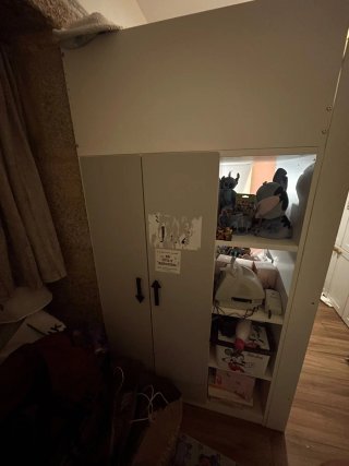 Cama alta tipo litera con escaleras y escritorio.