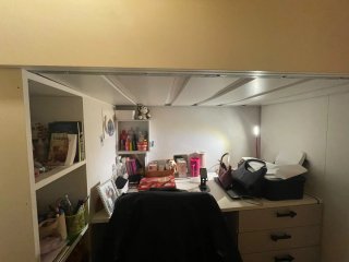Cama alta tipo litera con escaleras y escritorio.