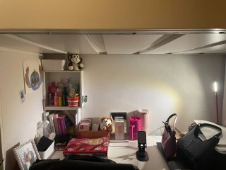 Cama alta tipo litera con escaleras y escritorio.