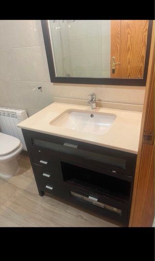 Mueble de baño con lavabo de piedra y espejo