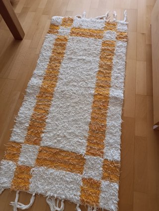 Alfombra tejida blanca y amarilla