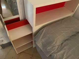 Mueble auxiliar blanco y rojo para la cama