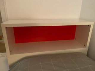 Mueble auxiliar blanco y rojo para la cama