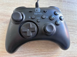 Consola Nintendo Switch negra con mando y funda.