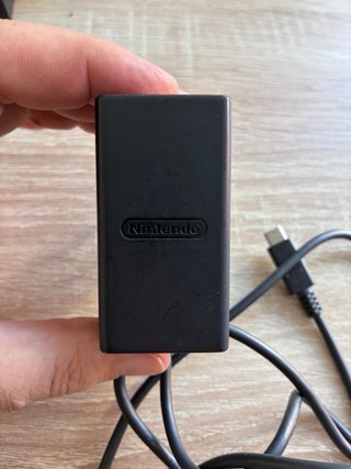 Consola Nintendo Switch negra con mando y funda.