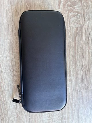 Consola Nintendo Switch negra con mando y funda.