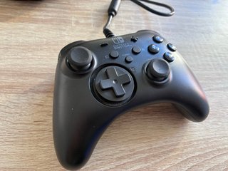 Consola Nintendo Switch negra con mando y funda.