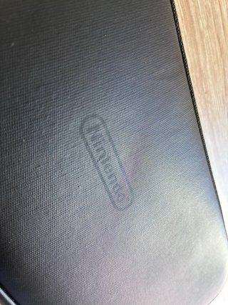Consola Nintendo Switch negra con mando y funda.
