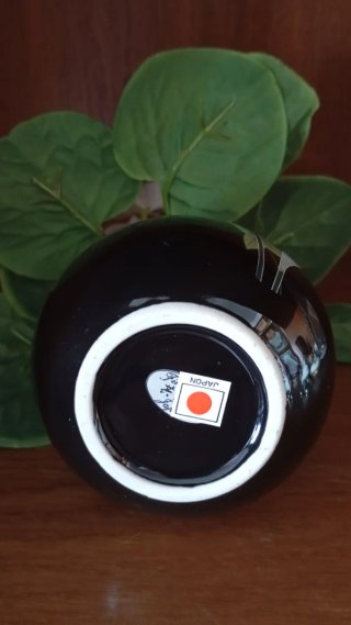 Jarrón negro con flores blancas artificiales